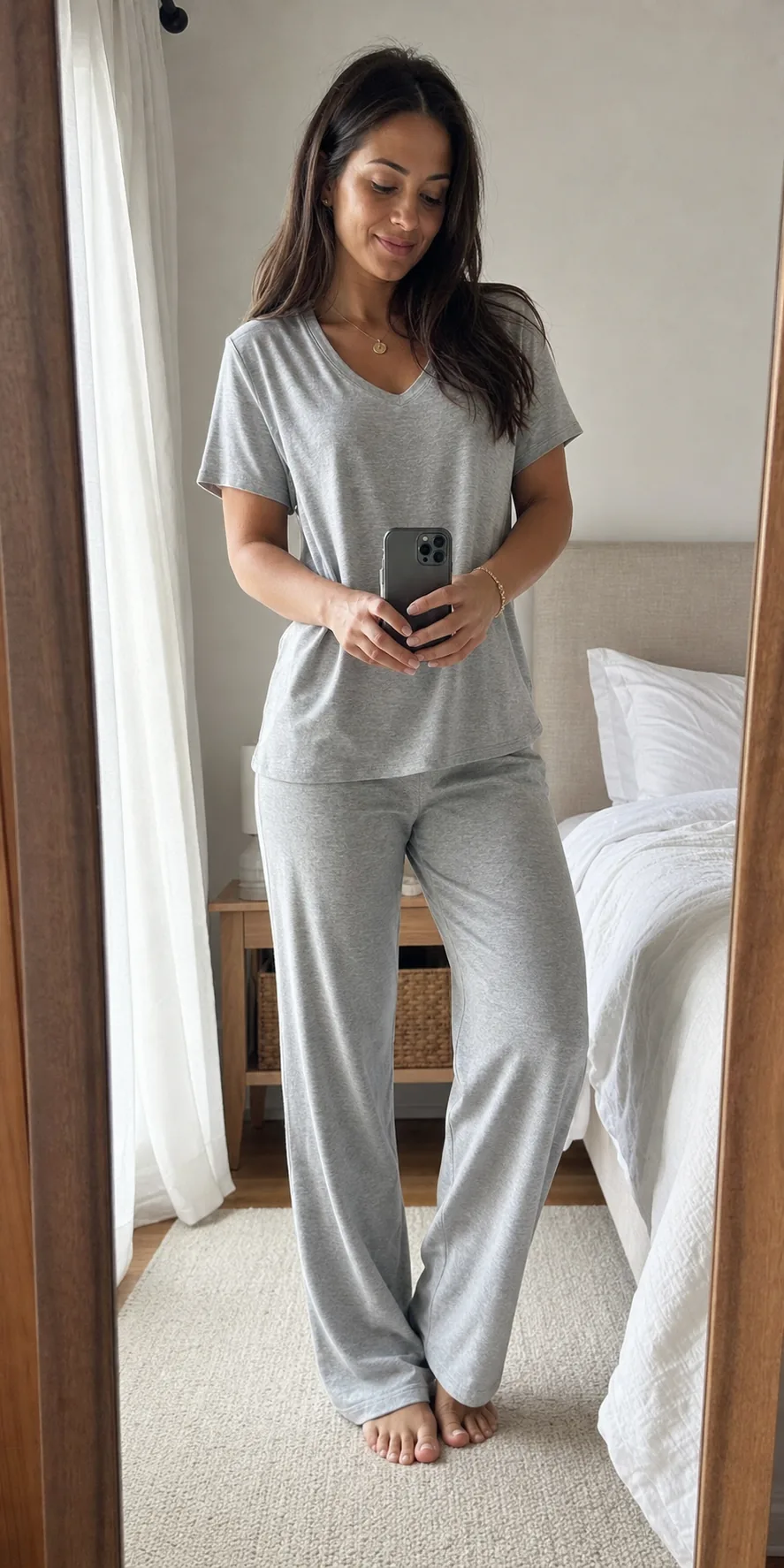 Creator wearing a grey pajama set in a bedroom mirror selfie